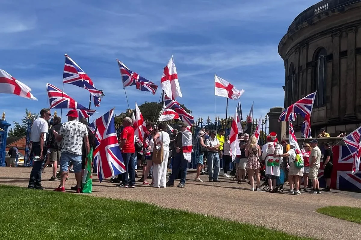 People gathered outdoors in Shrewsbury beneath Union flags