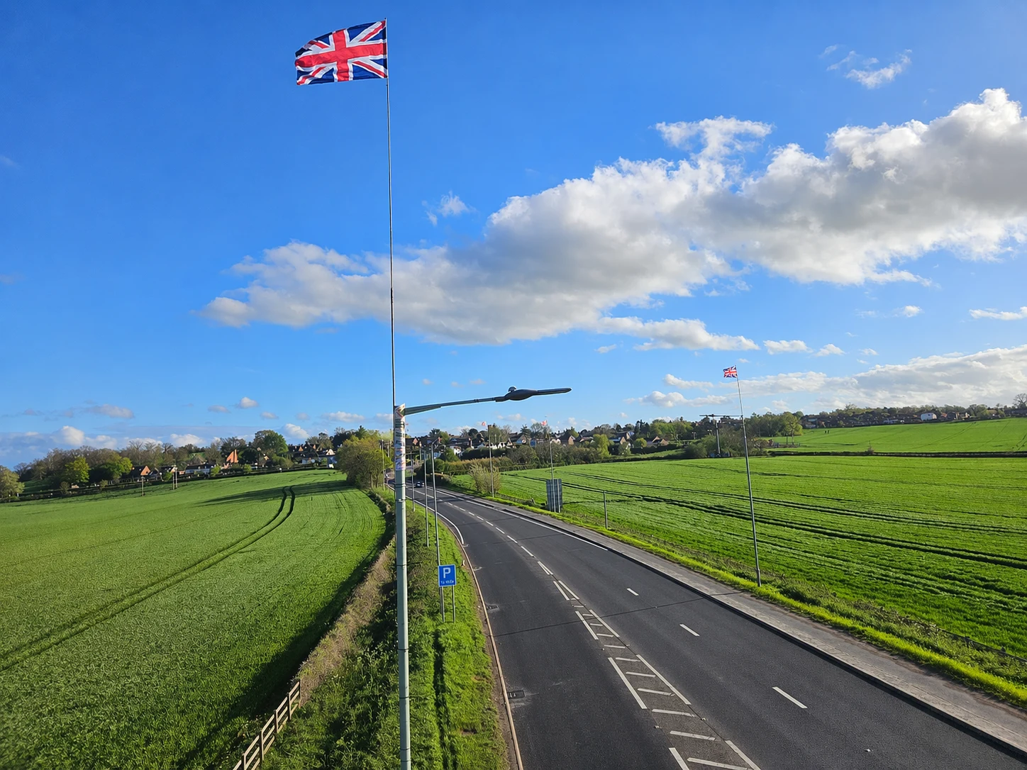 Union flags flying beside a road through the green countryside around Shrewsbury